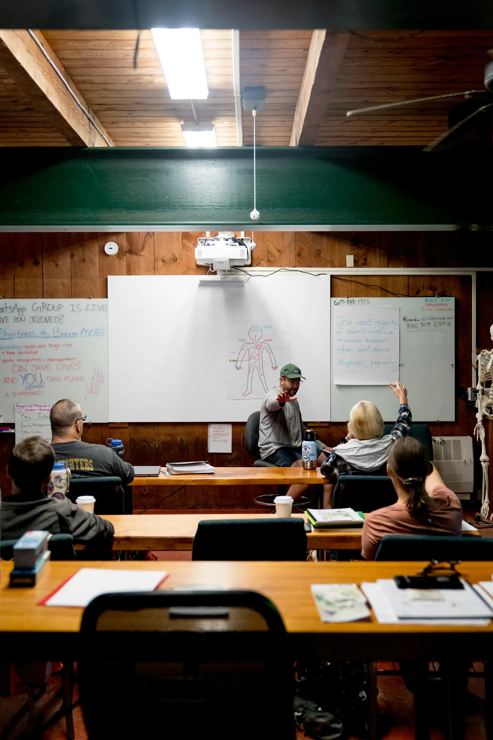 An instructor at a whiteboard teaching a small class of adults