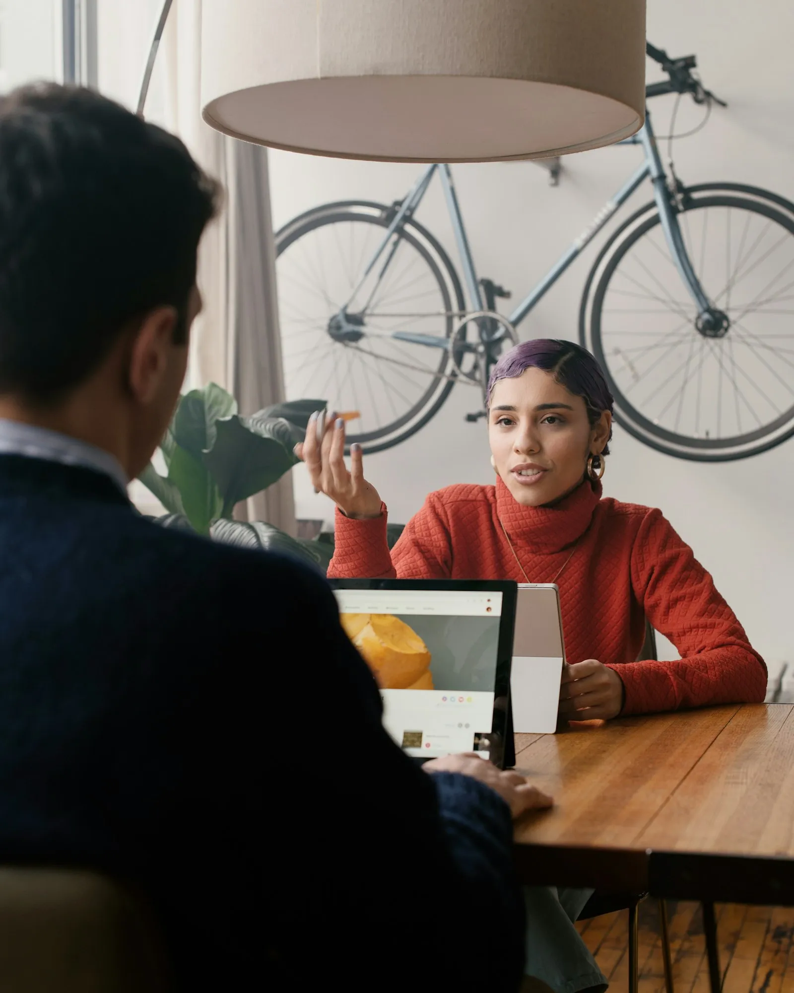 Two people talking across a table during a client meeting